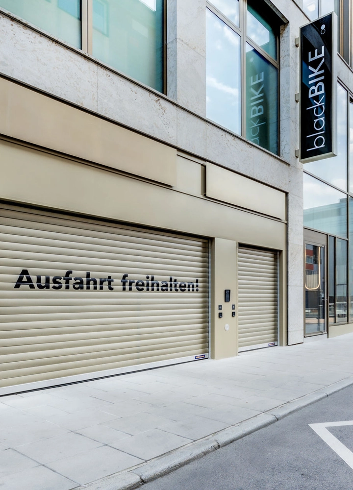 Gebäudefassade mit dem Schild „blackBIKE“ und dem Hinweis „Ausfahrt freihalten!“ an einem Rolltor