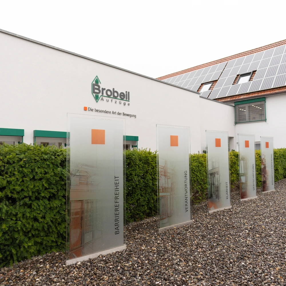 Gebäude von Brobeil Aufzüge mit Solaranlage und Glasstelen zu Barrierefreiheit, Verantwortung und Klarheit