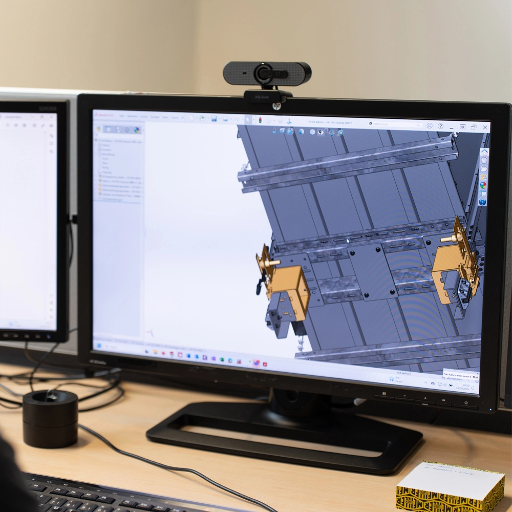 Monitor mit einer 3D-CAD-Darstellung eines technischen Bauteils auf einem Schreibtisch